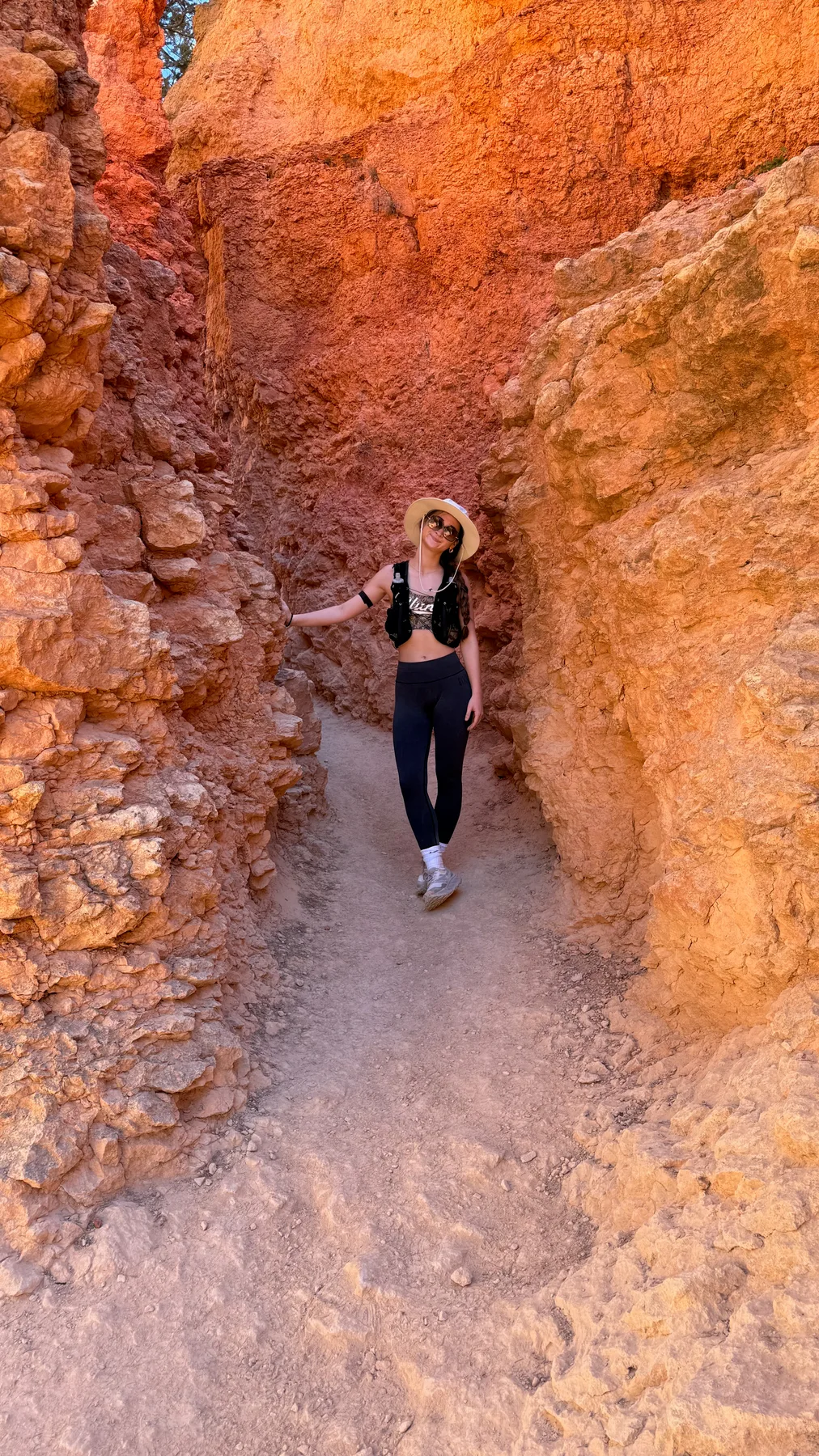 Lyla on a narrow trail between orange canyon walls in Bryce Canyon