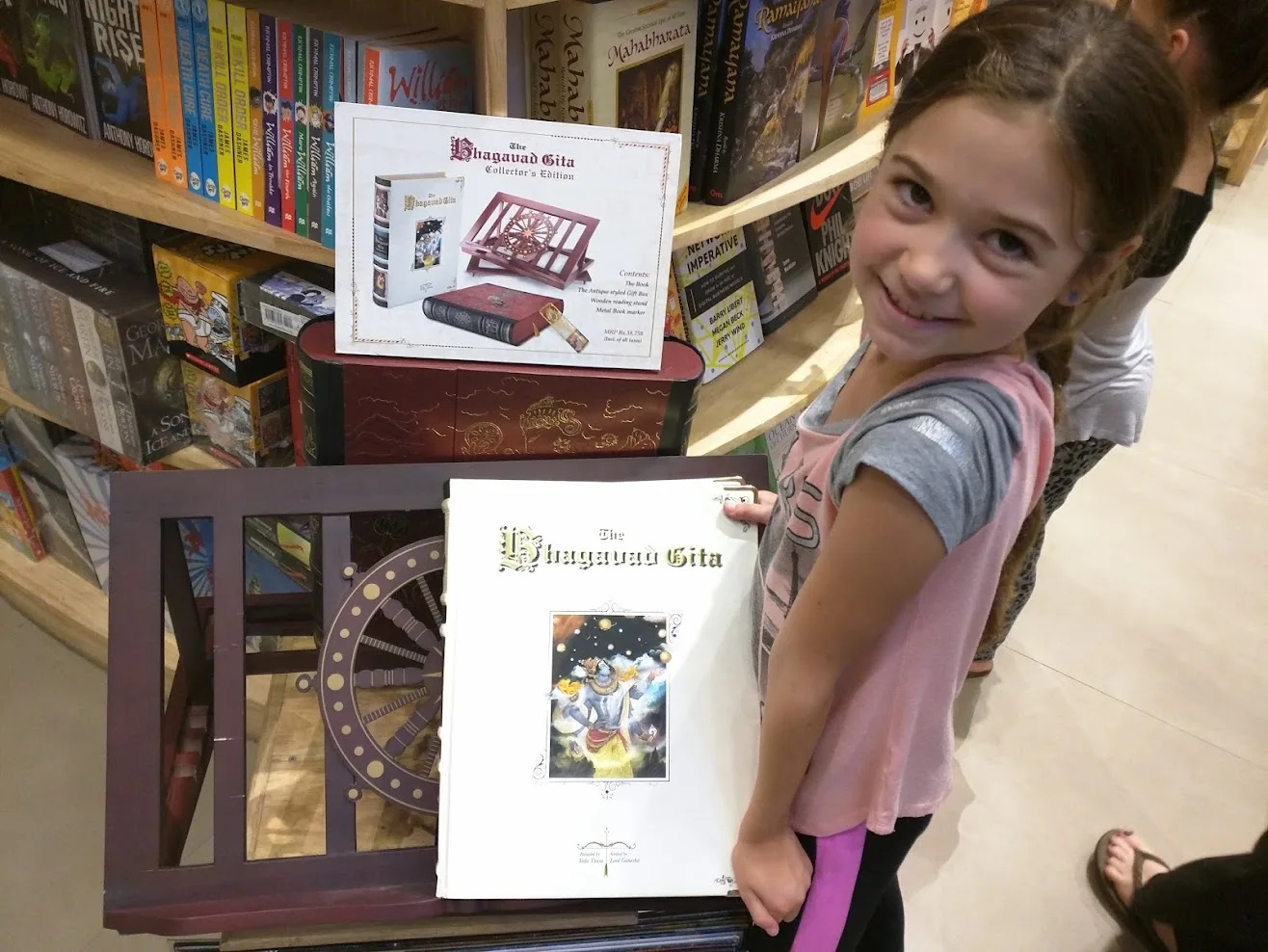 A smiling girl beside a book display