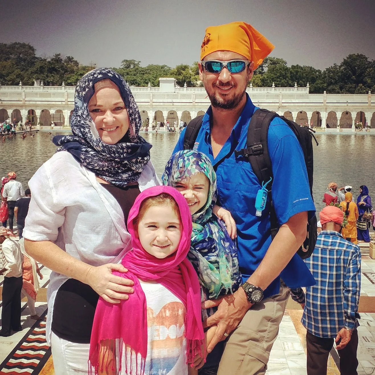 Family of four beside the temple pool in Delhi