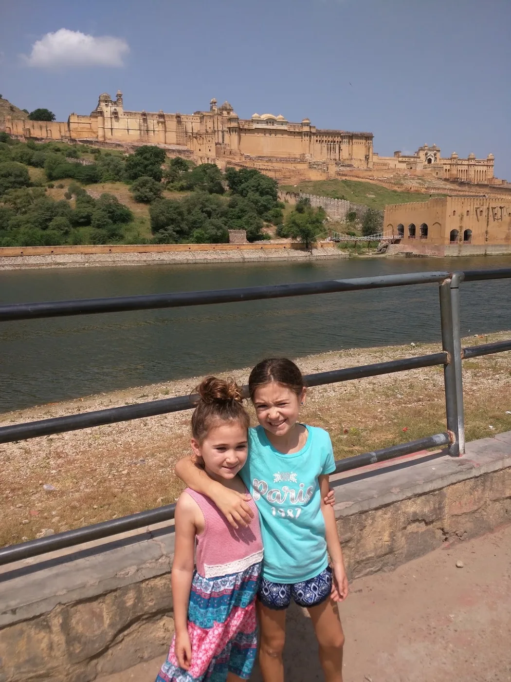 Two sisters beside a lake with a hill fort behind them