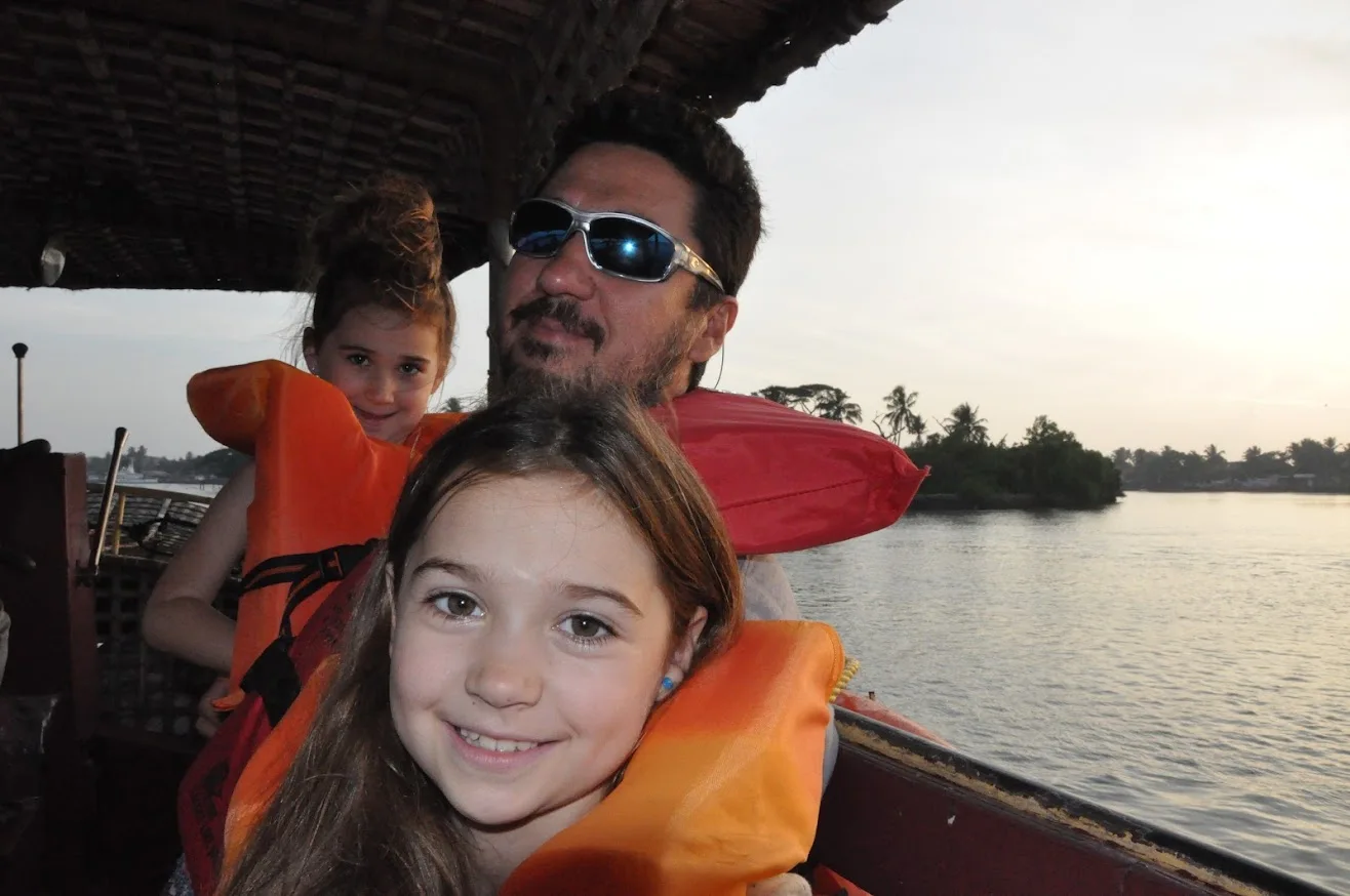 Josh and the girls wearing life jackets on a boat