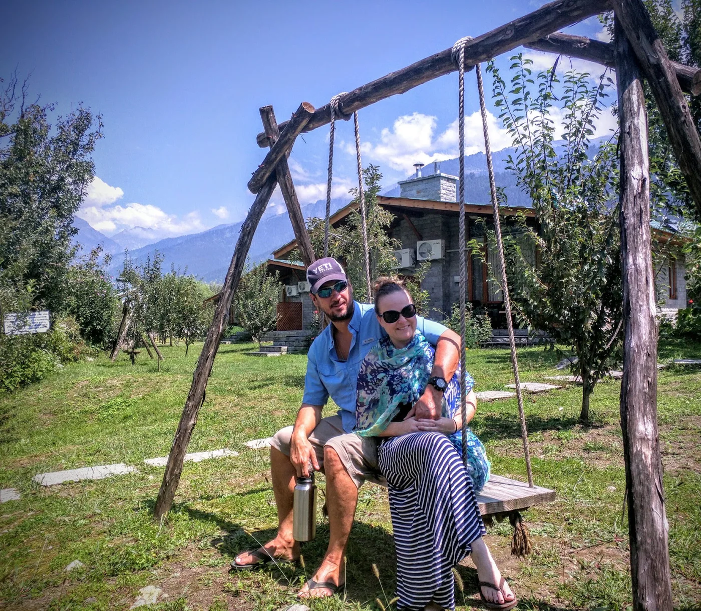 Josh and Morgan sitting on a swing in the mountains