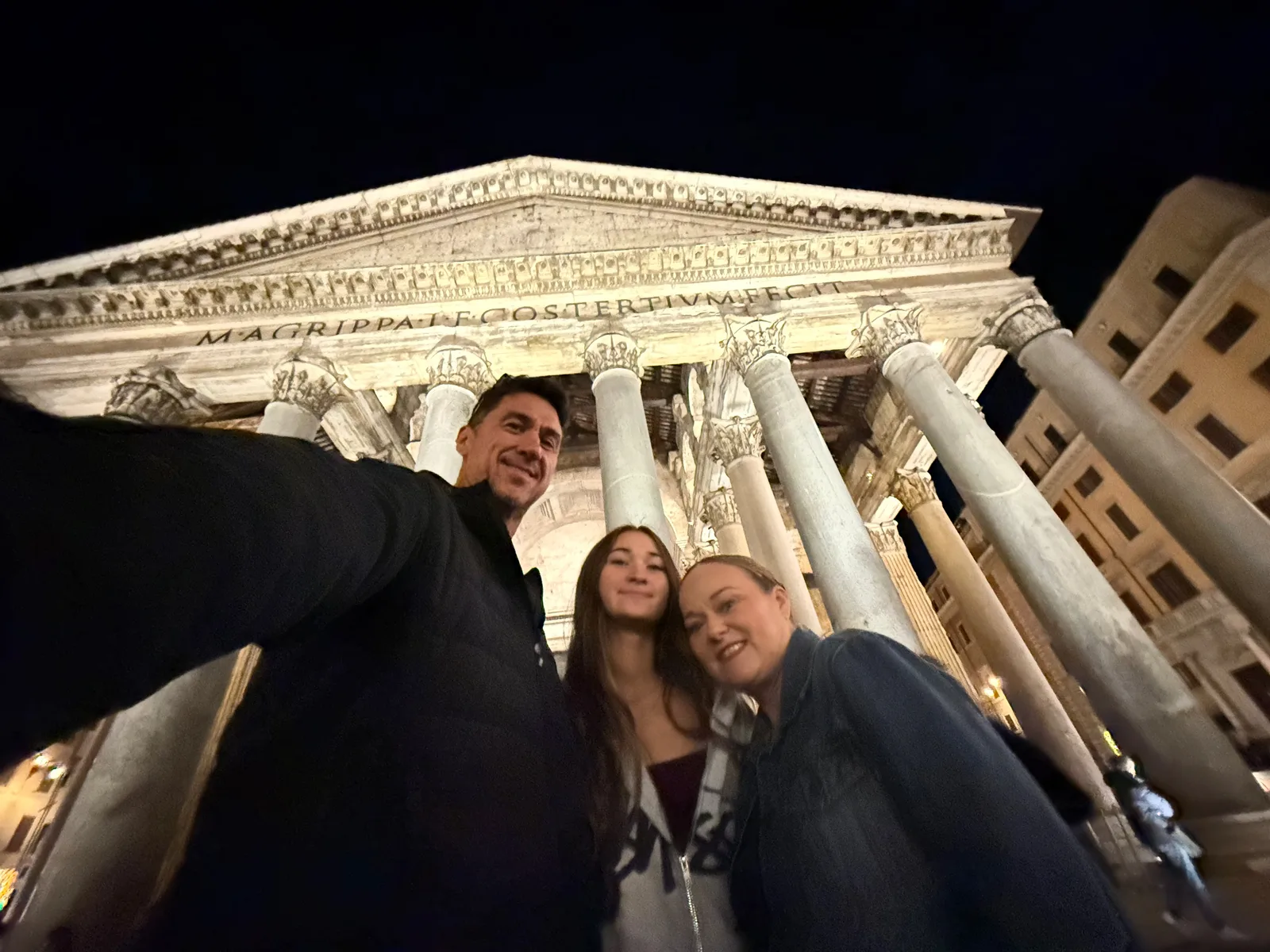 Family selfie outside the illuminated Pantheon at night