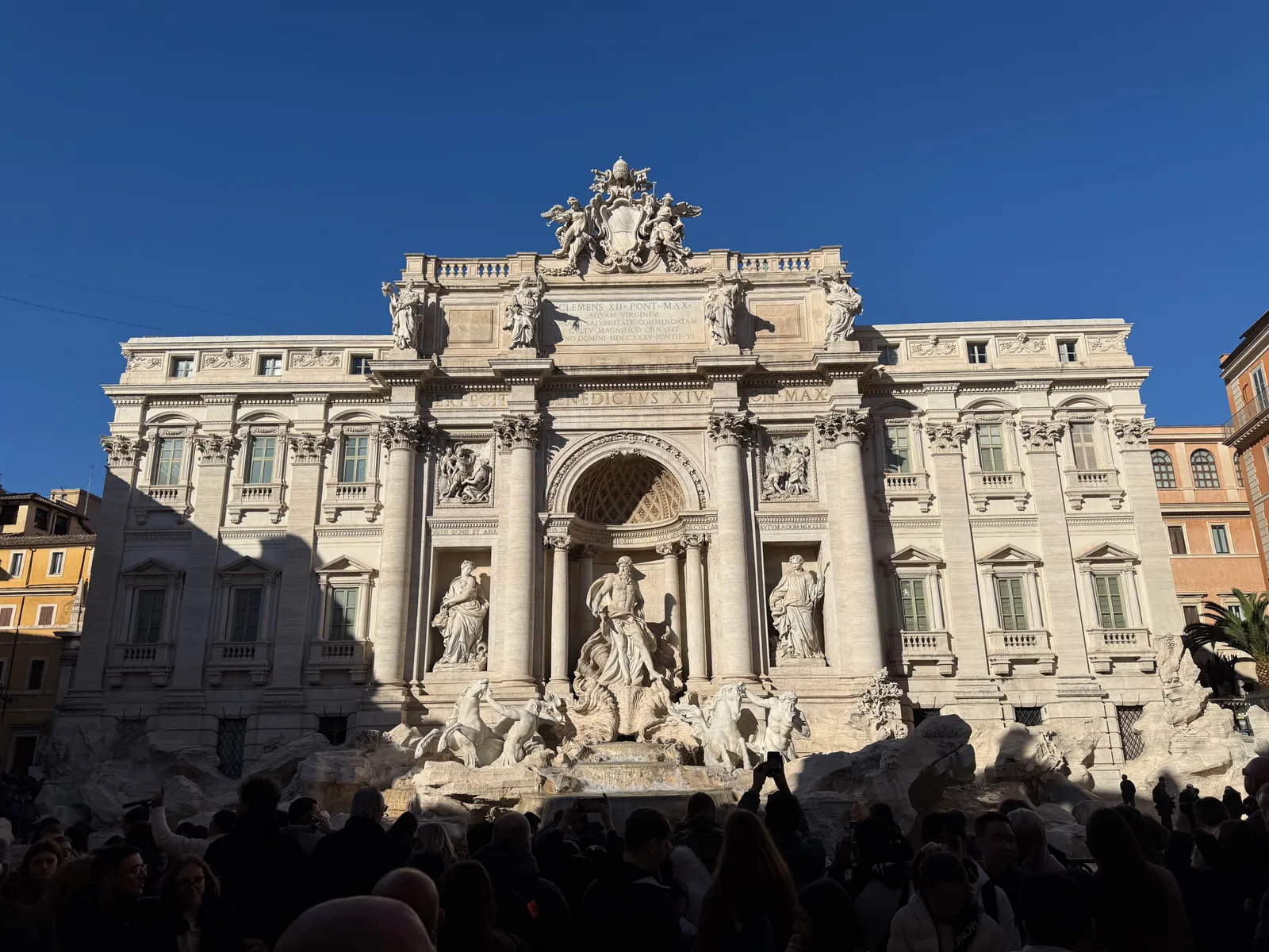 Trevi Fountain in sunlight beneath a clear blue sky