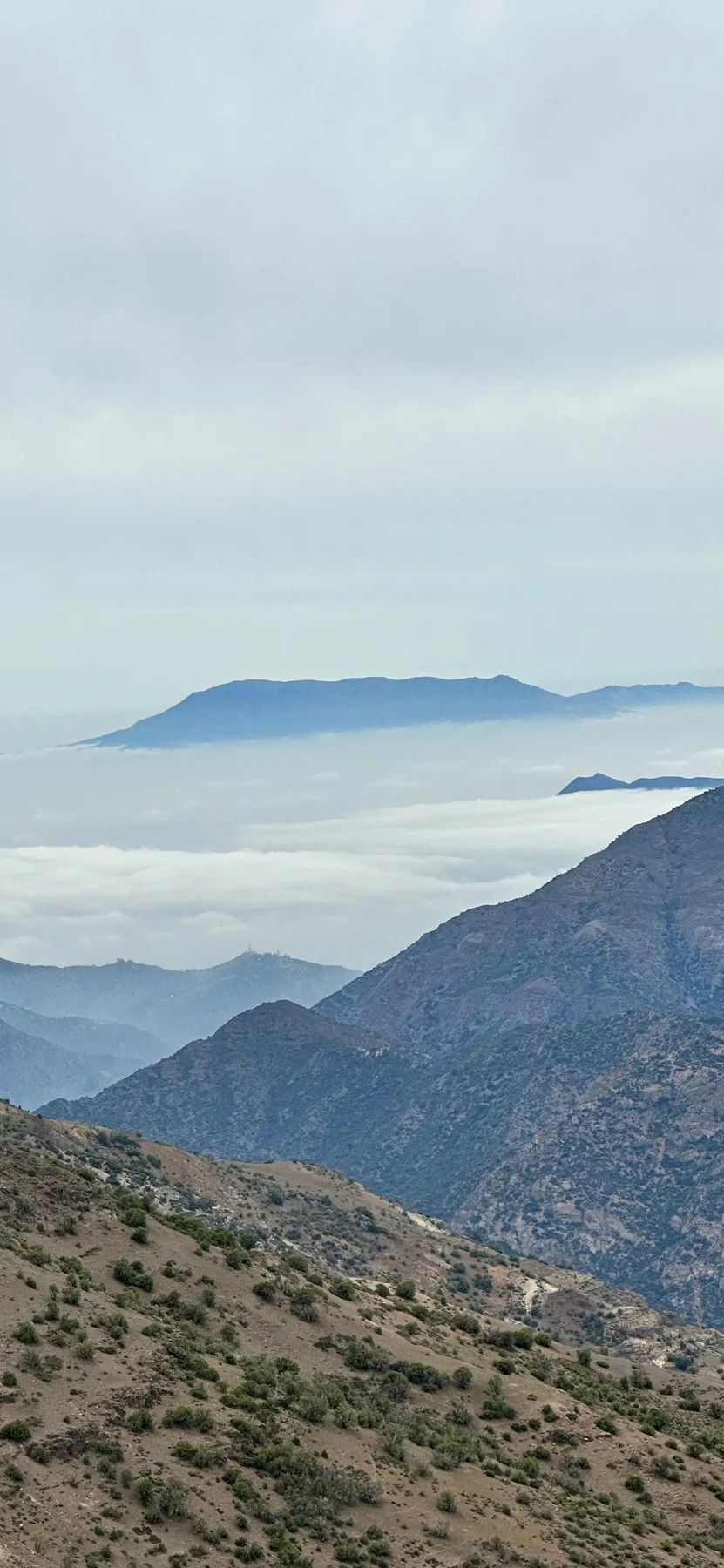 Mountain ridges rising above low clouds near Santiago